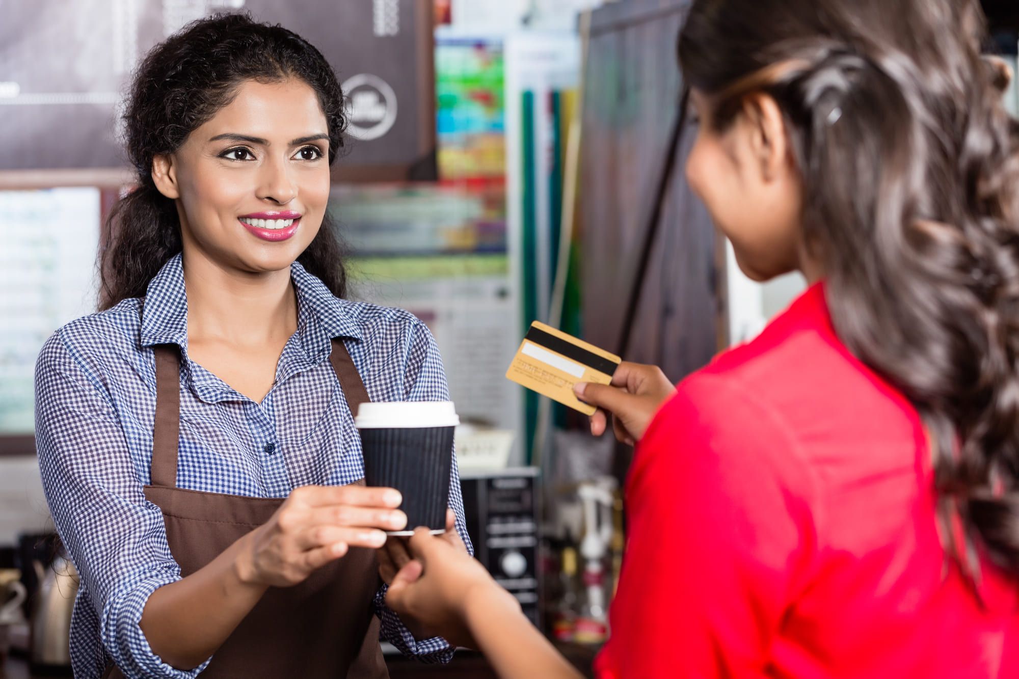 カードでコーヒーを買う女性と女性店員